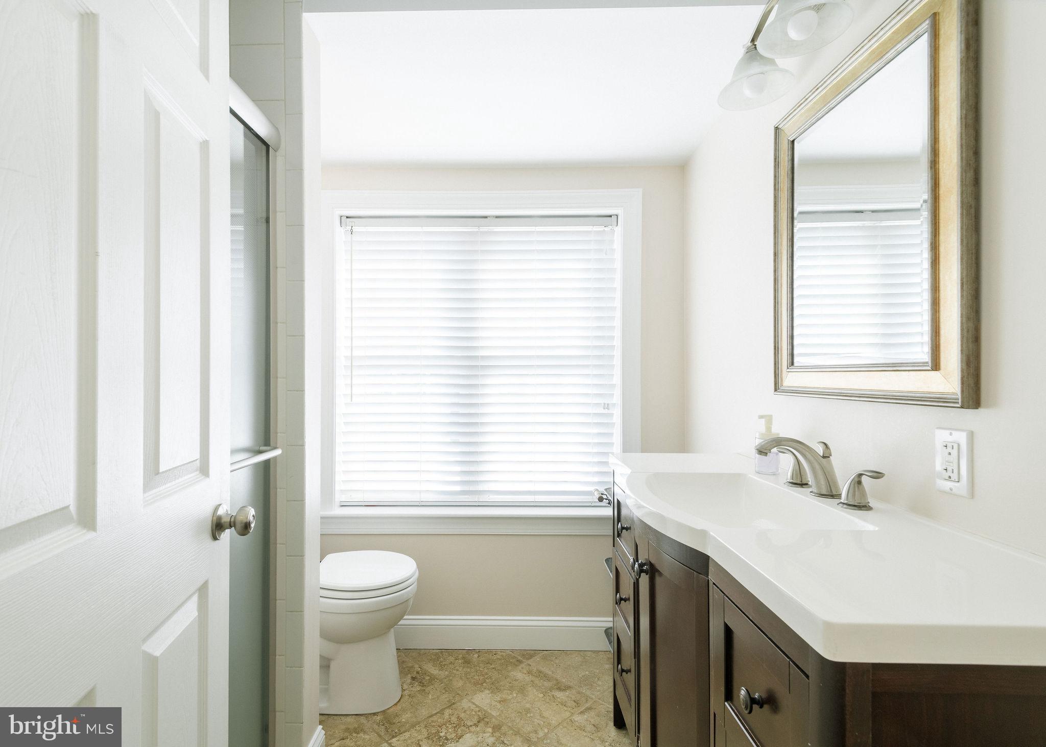 25 North Rolling Road Springfield, PA 19064 - Photo 23 of 45 a bathroom with a sink a toilet and a window