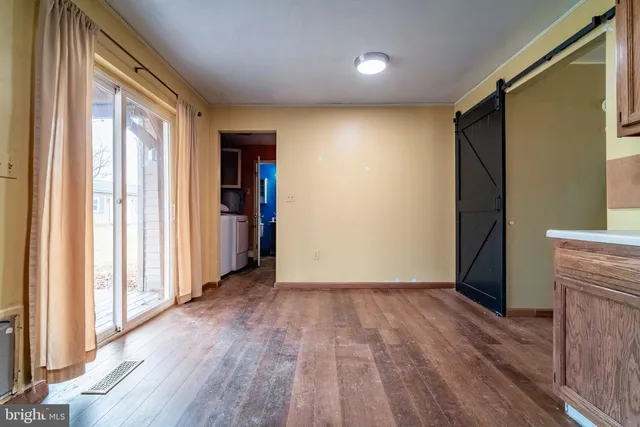 an empty room with wooden floor and a window