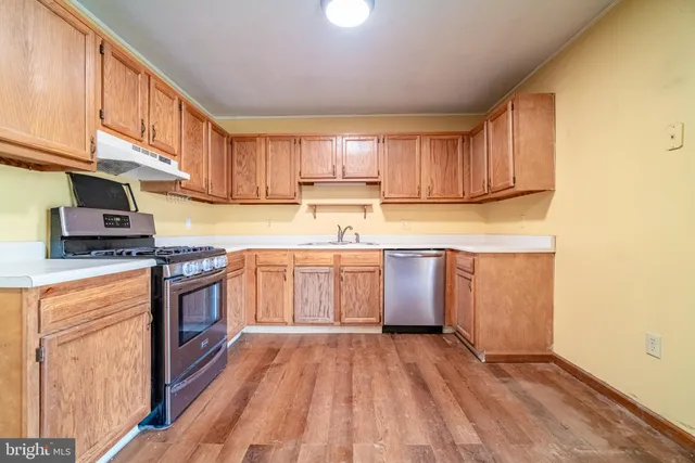 a kitchen with a white cabinets a sink and wooden floor