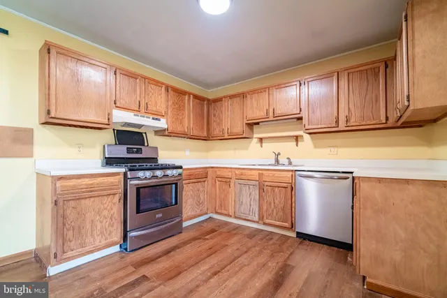 a kitchen with stainless steel appliances granite countertop a stove a sink and a microwave