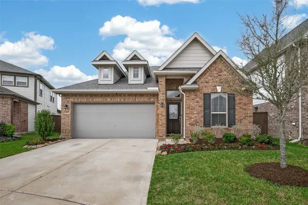 a front view of a house with a garden and trees