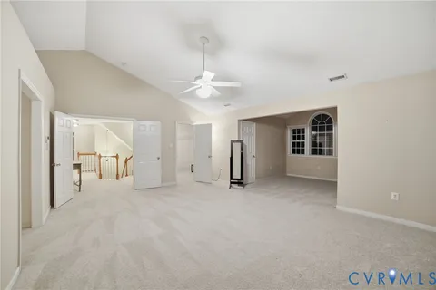 an empty room with windows and ceiling fan