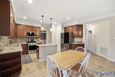 a kitchen with stainless steel appliances granite countertop a stove refrigerator sink and cabinets