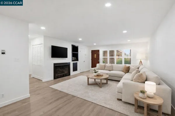 a living room with furniture a fireplace and a flat screen tv