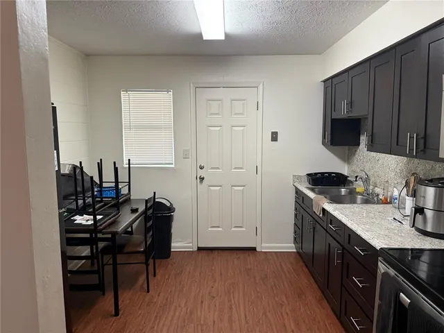 a kitchen with a sink cabinets and wooden floor