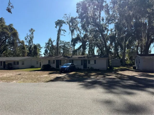 a backyard of a house with trees and wooden fence