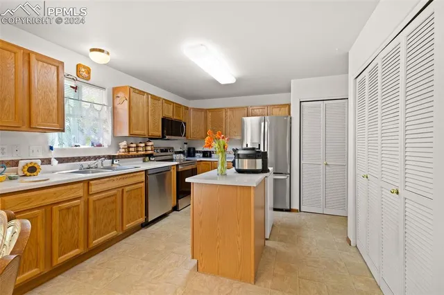 a kitchen with stainless steel appliances granite countertop a stove a sink dishwasher a refrigerator and a microwave oven