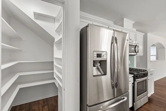 a kitchen with stainless steel appliances a refrigerator and a stove top oven