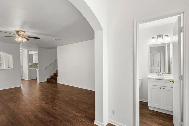 a view of a hallway with wooden floor and a kitchen
