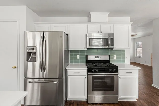 a kitchen with stainless steel appliances wooden cabinets and a stove