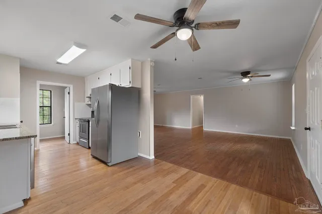 a view of a livingroom with a ceiling fan wooden floor and a ceiling fan