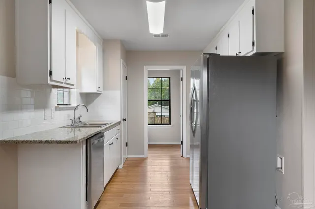 a kitchen with granite countertop a sink and cabinets
