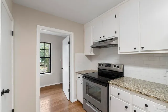 a kitchen with granite countertop white cabinets and white appliances