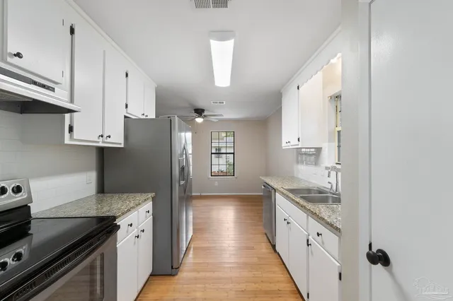 a kitchen with granite countertop a sink and a stove