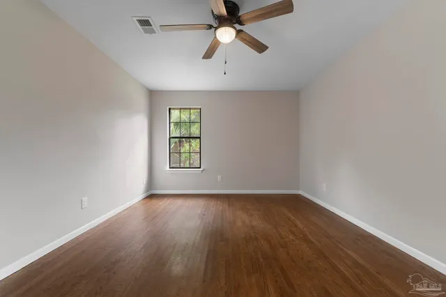 wooden floor in an empty room with a window