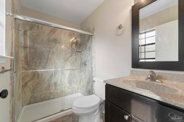 a bathroom with a granite countertop sink toilet and shower