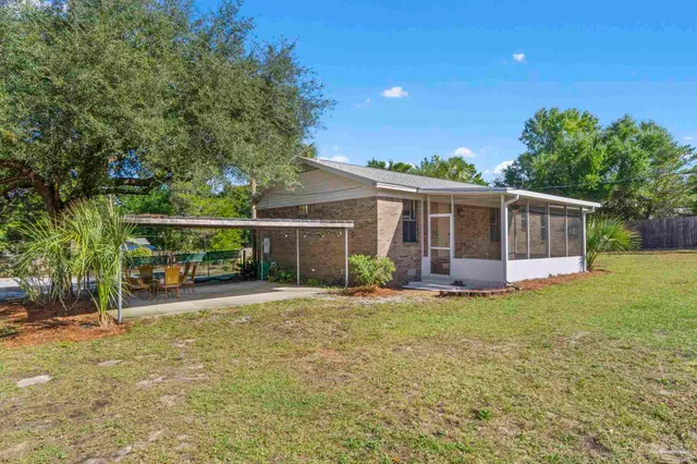 a view of a house with a yard and sitting area
