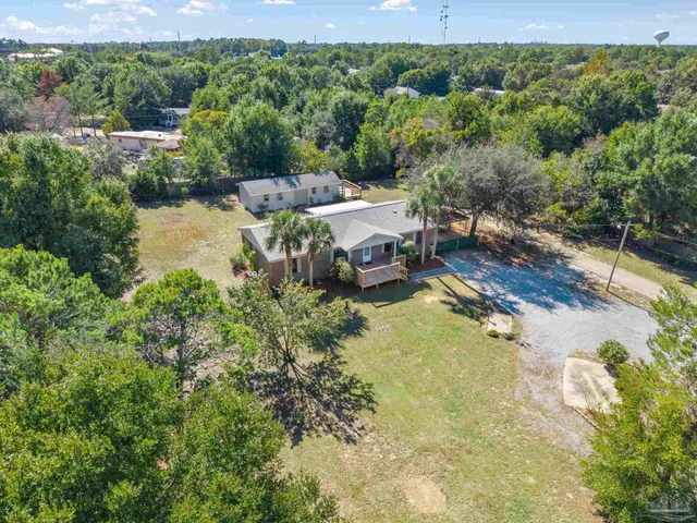 an aerial view of a house with a yard and lake view
