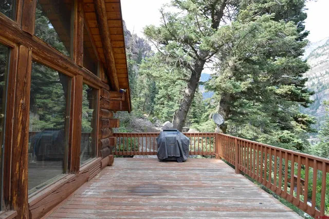 a balcony with wooden floor and yard in the back