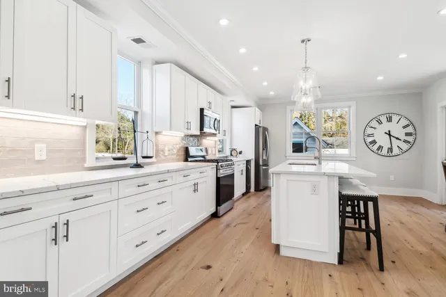 a kitchen with white cabinets and stainless steel appliances