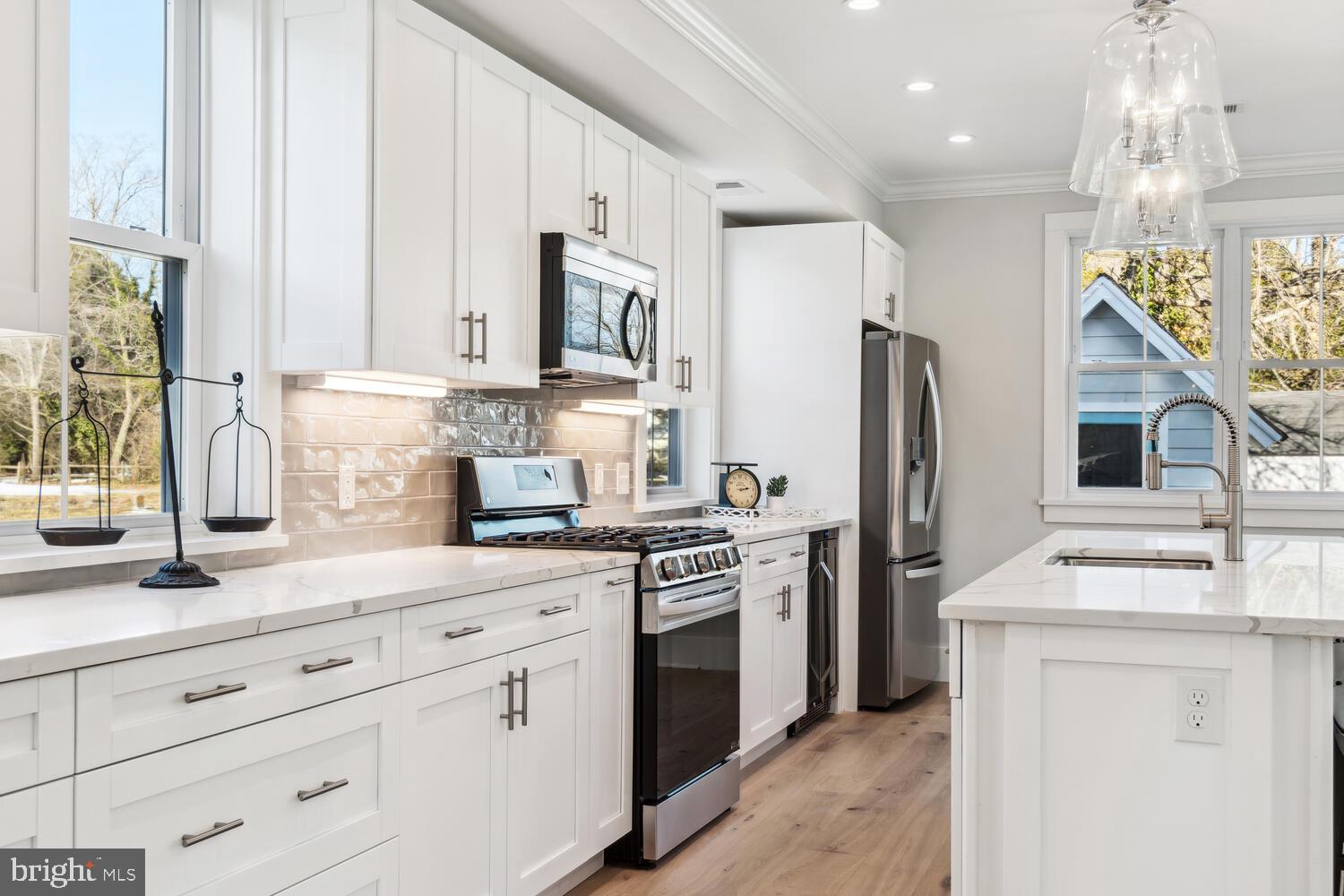 8013 Ruby Harrison Road St. Michaels, MD 21663 - Photo 13 of 47 a kitchen with white cabinets and stainless steel appliances