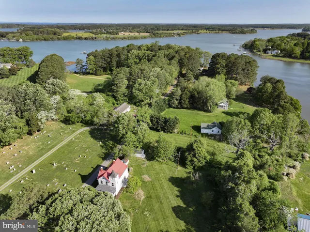 an aerial view of residential houses with outdoor space and lake view
