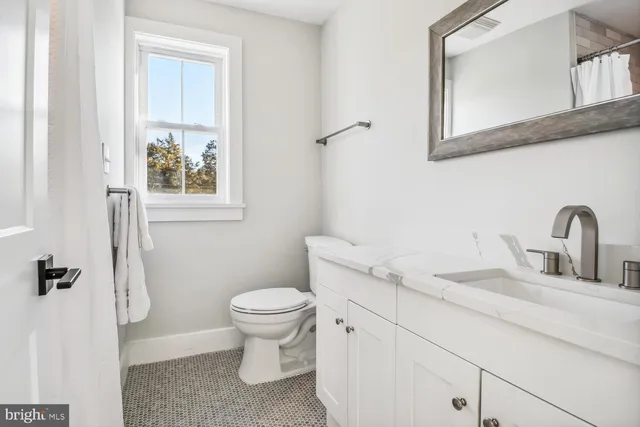 a bathroom with a sink shower and a mirror