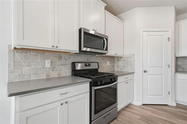 a kitchen with a stove a sink and a microwave