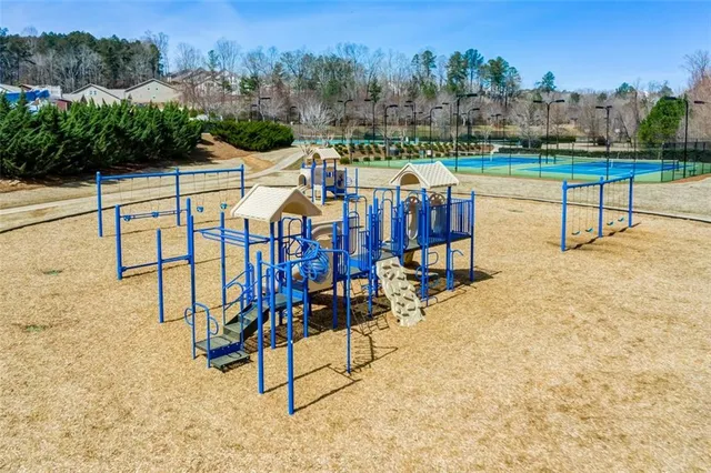 a view of a tennis ground with large trees