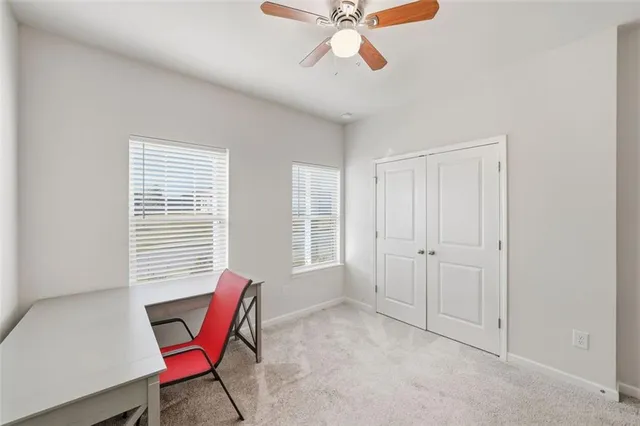 a view of a workspace with furniture and a window