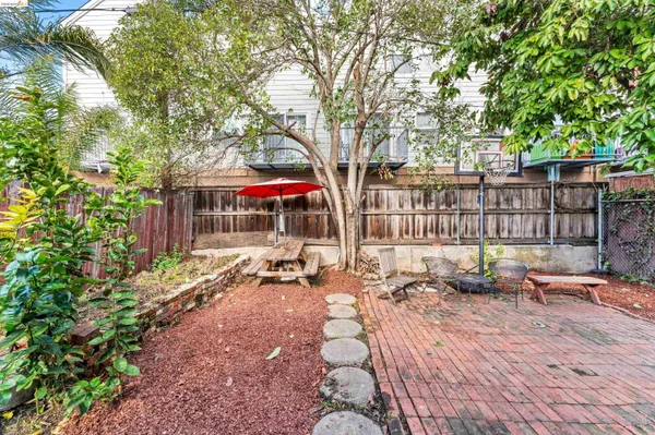 a view of a patio with table and chairs and wooden fence