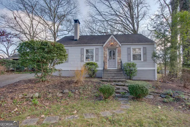a front view of a house with a yard and potted plants