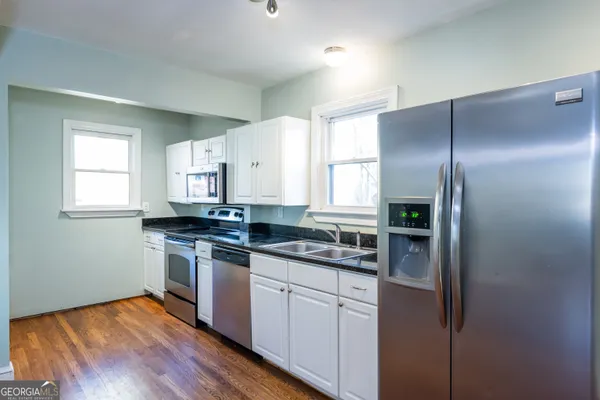 a kitchen with stainless steel appliances granite countertop a stove a sink and a refrigerator