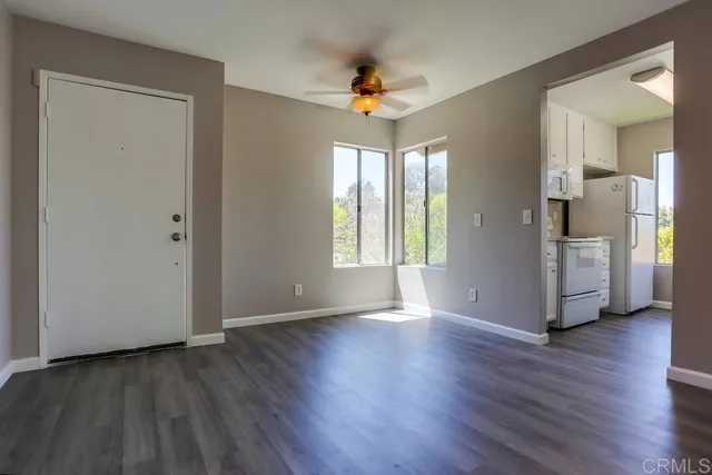 a view of a kitchen with wooden floor and a ceiling fan
