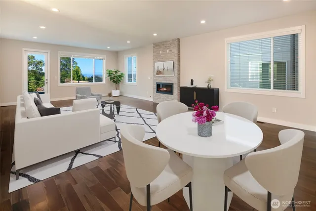 a living room with furniture kitchen view and a large window