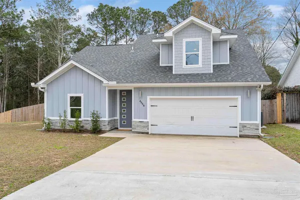 a view of a house with a yard and large tree
