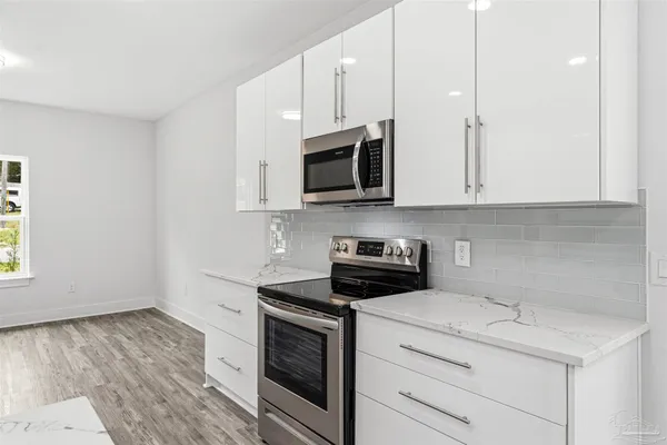 a kitchen with stainless steel appliances granite countertop a stove and a microwave