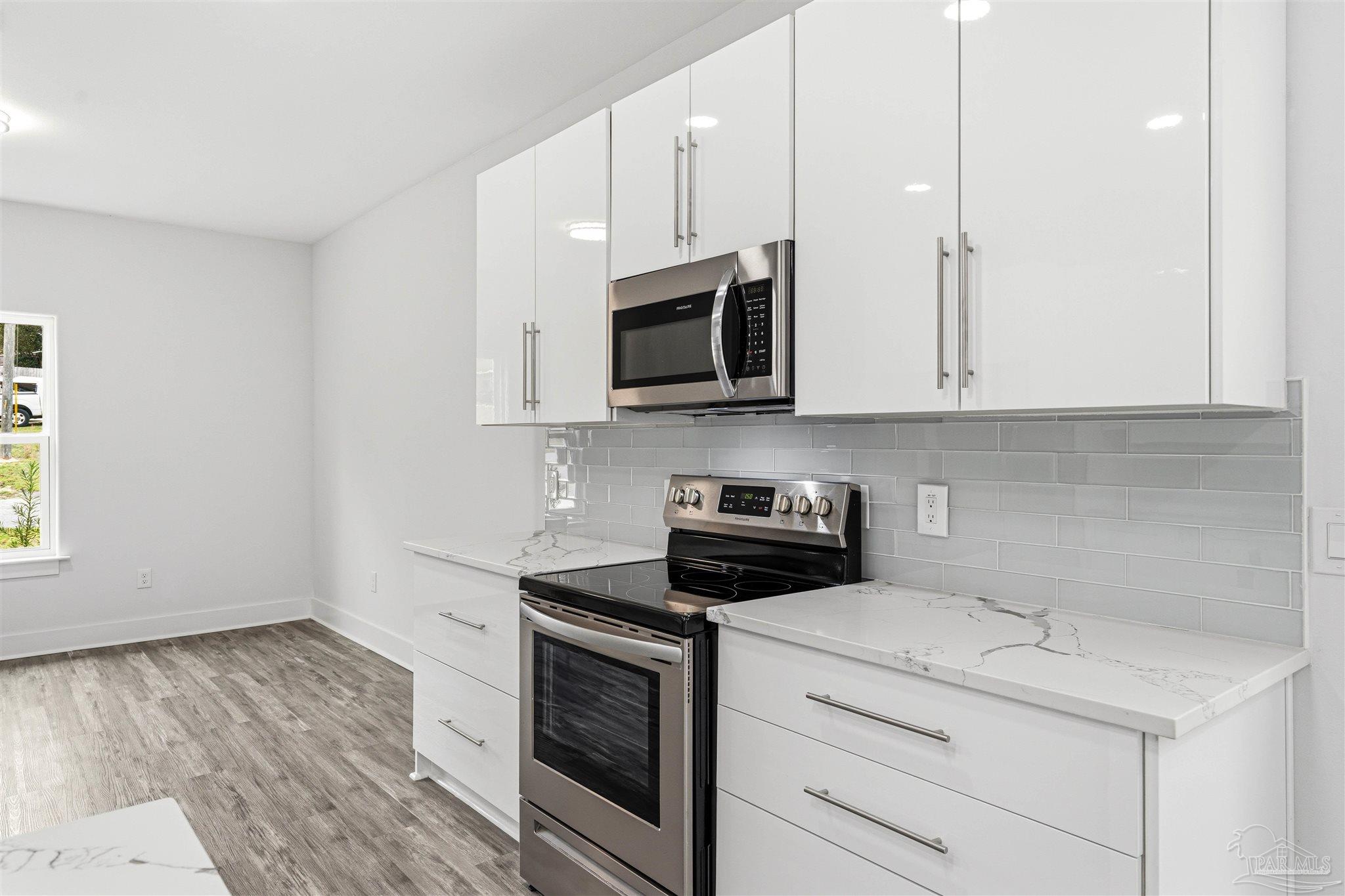 4446 Antioch Road Crestview, FL 32536 - Photo 11 of 43 a kitchen with stainless steel appliances granite countertop a stove and a microwave