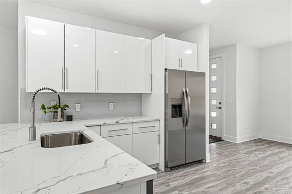 a kitchen with a refrigerator sink and cabinets