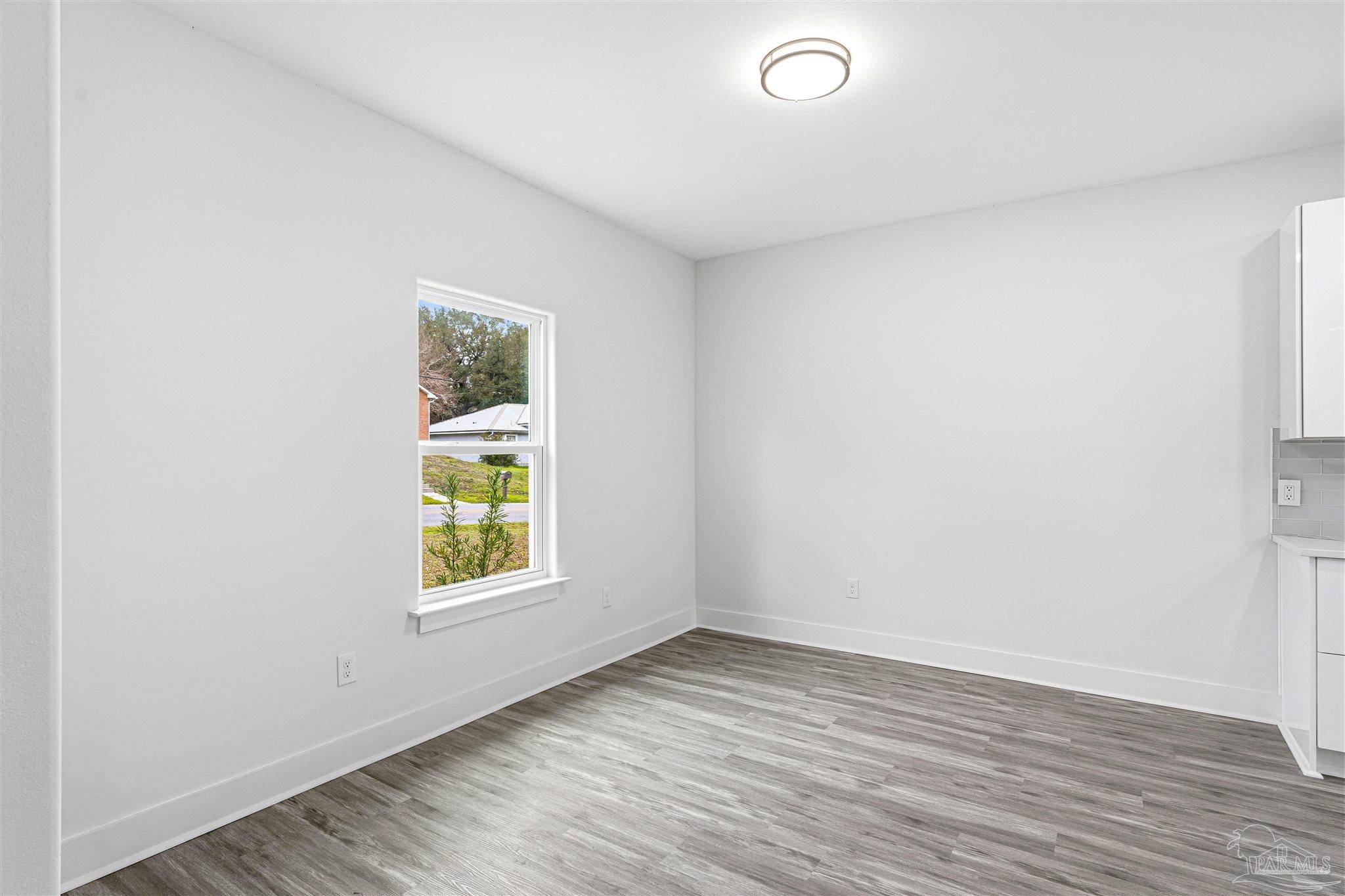 4446 Antioch Road Crestview, FL 32536 - Photo 14 of 43 an empty room with wooden floor and windows