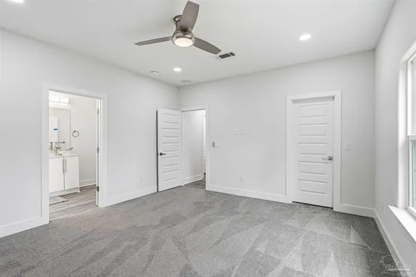 an empty room with closet and a ceiling fan