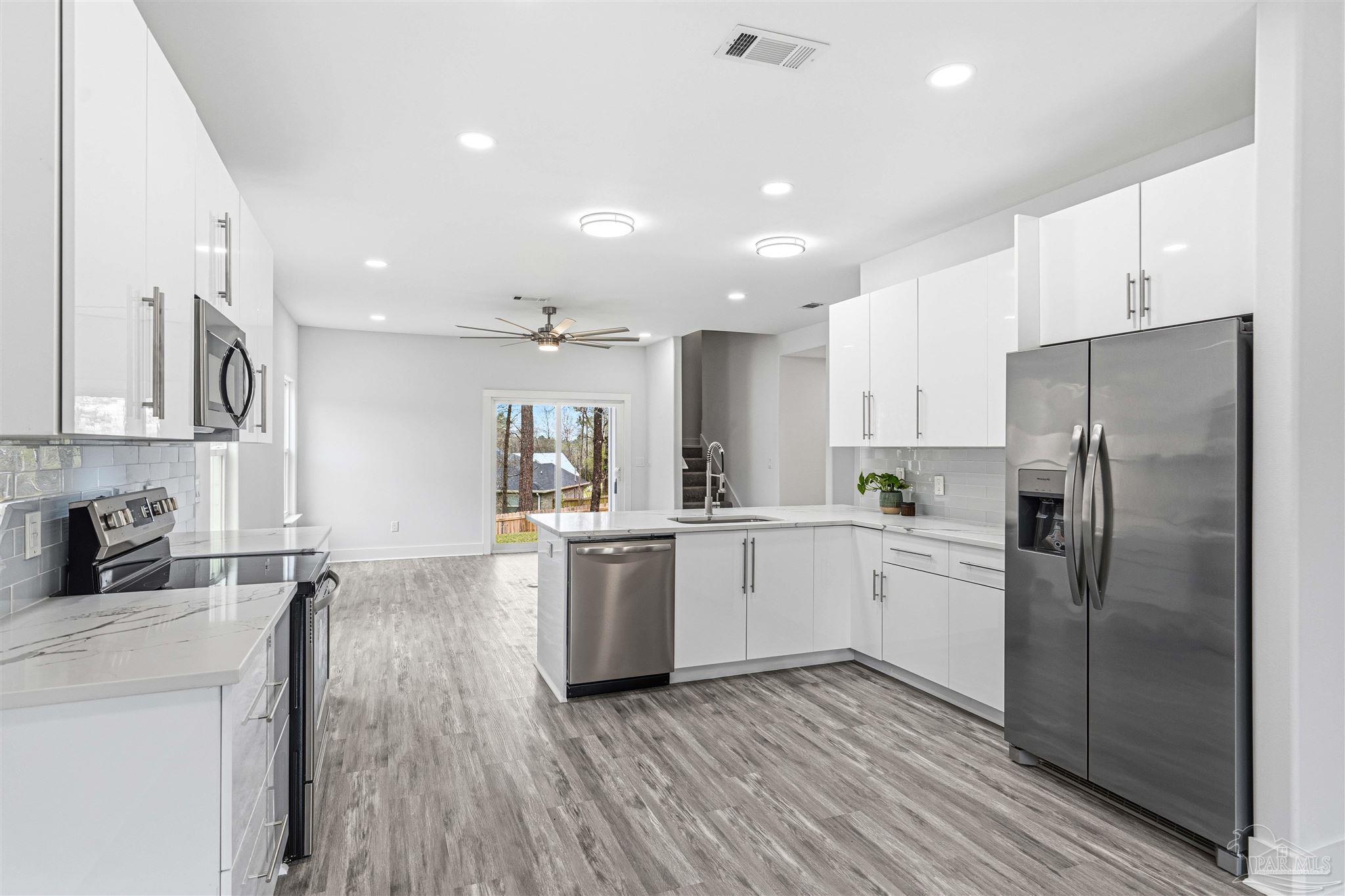 4446 Antioch Road Crestview, FL 32536 - Photo 2 of 43 a kitchen with stainless steel appliances granite countertop a refrigerator sink and white cabinets