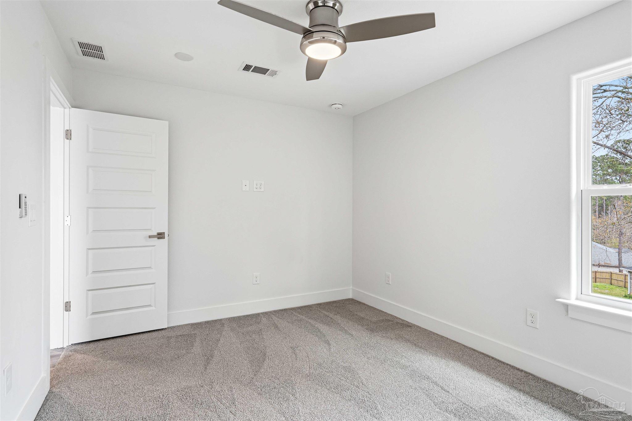 4446 Antioch Road Crestview, FL 32536 - Photo 22 of 43 an empty room with windows and ceiling fan