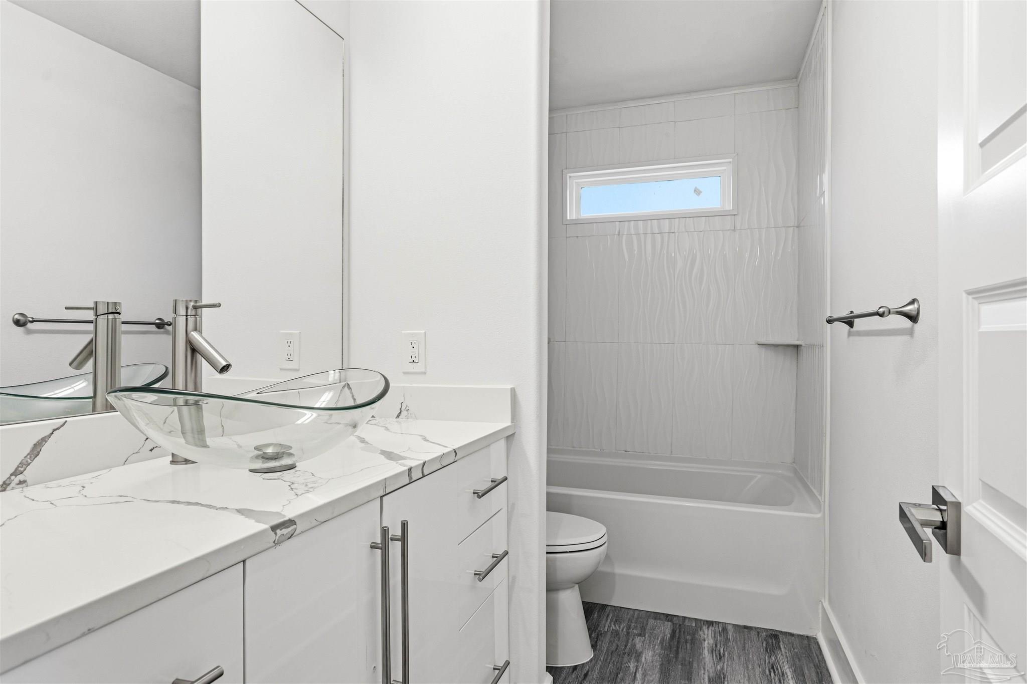 4446 Antioch Road Crestview, FL 32536 - Photo 24 of 43 a bathroom with a granite countertop sink toilet and shower