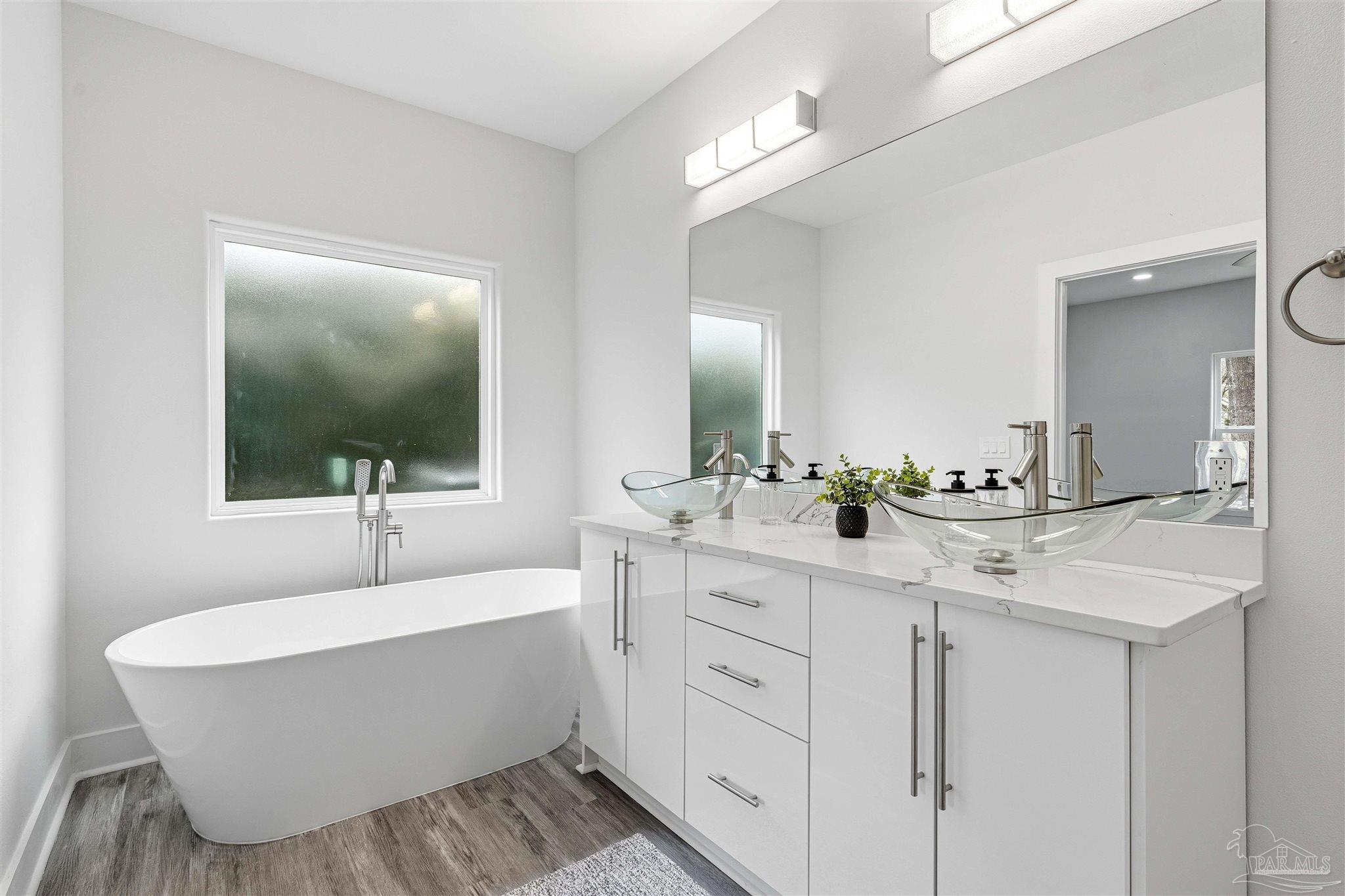 4446 Antioch Road Crestview, FL 32536 - Photo 3 of 43 a bathroom with a white tub a sink and mirror