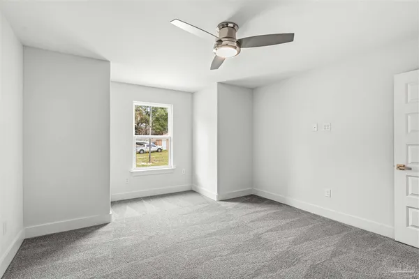 an empty room with a window and a fan