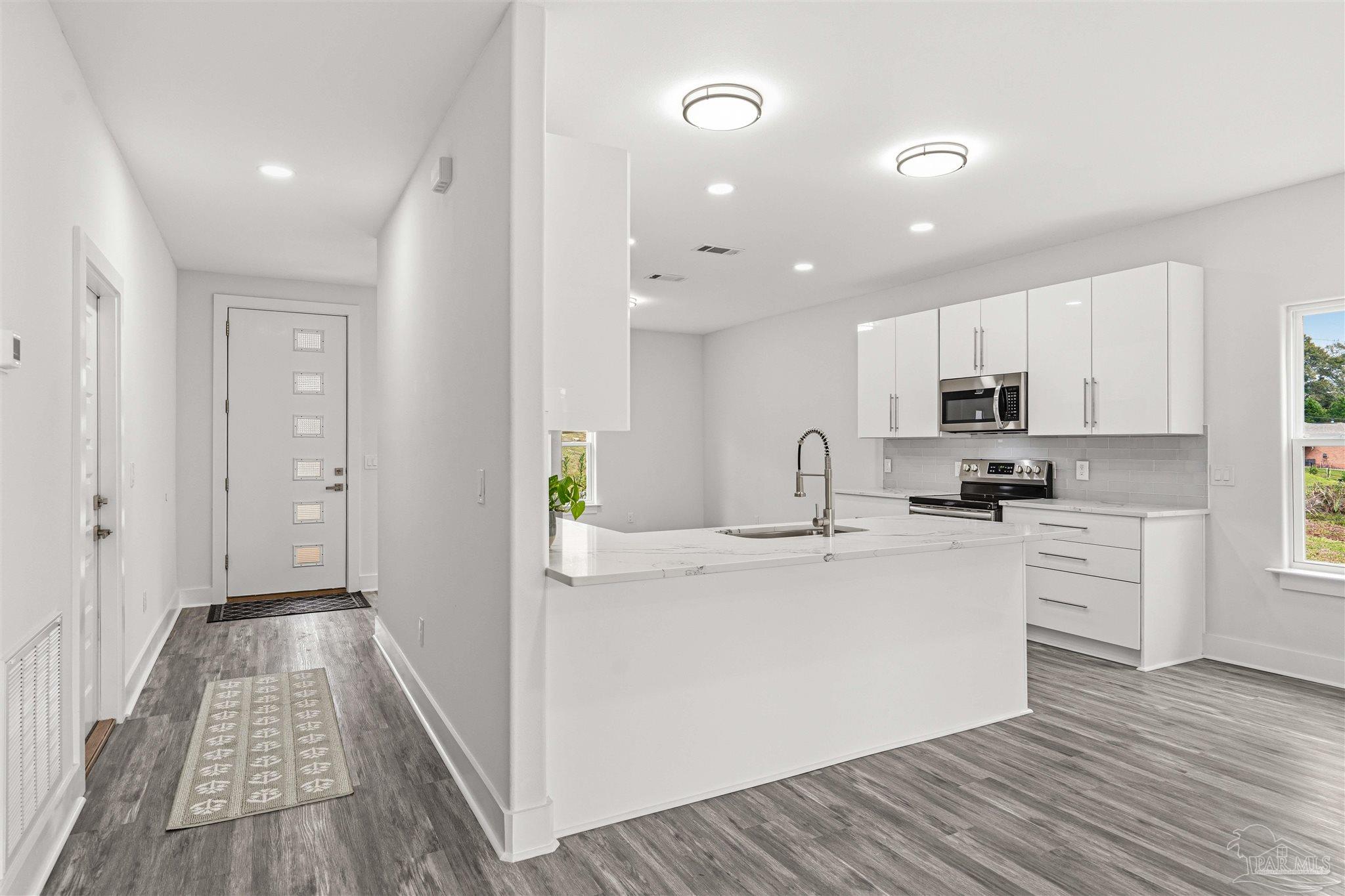 4446 Antioch Road Crestview, FL 32536 - Photo 4 of 43 a view of a kitchen with kitchen island a sink wooden floor and stainless steel appliances