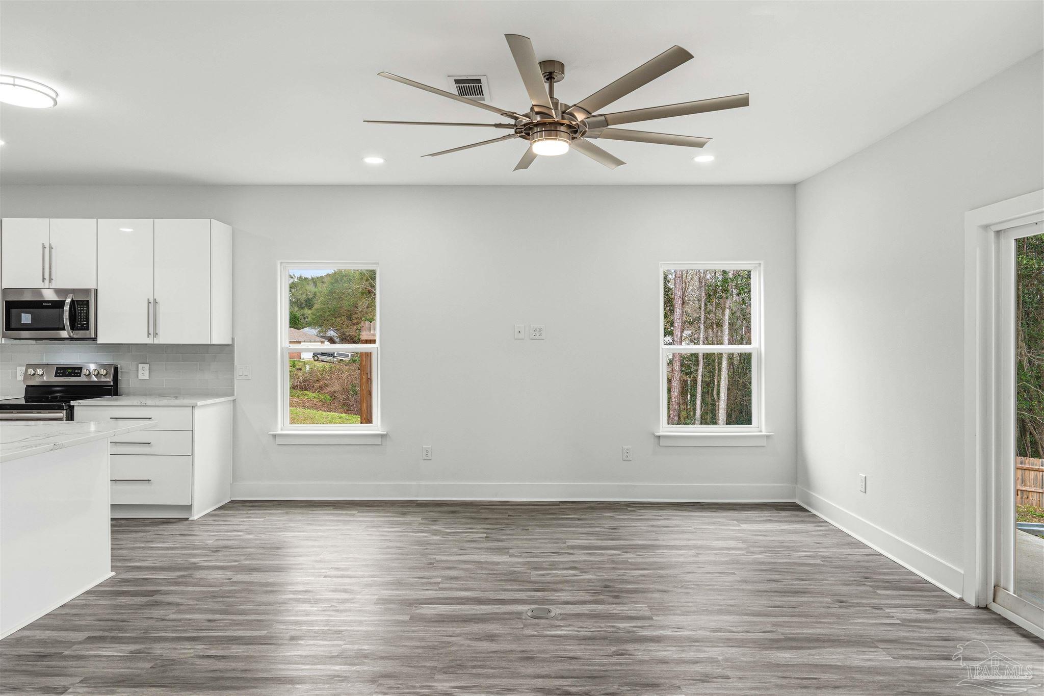 4446 Antioch Road Crestview, FL 32536 - Photo 6 of 43 a view of an empty room with a window and wooden floor