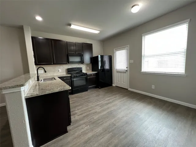 a kitchen with stainless steel appliances granite countertop a refrigerator and a sink