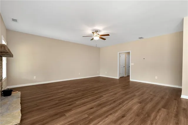 a view of a room with wooden floor and a ceiling fan